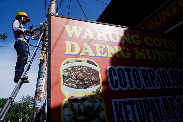 Teknisi ICONNET melakukan pemasangan pemasangan jaringan internet di Warung Coto Makassar.