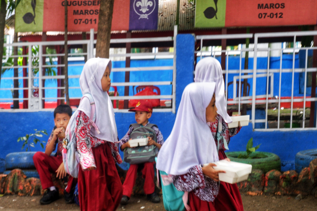 Sejumlah siswa menerima nasi dos saat uji coba pemberian makanan bergizi gratis di SDN 103 Inpres Hasanuddin, Kabupaten Maros.