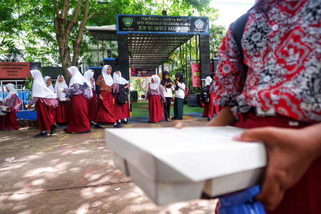 Sejumlah siswa menerima nasi dos saat uji coba pemberian makanan bergizi gratis di SDN 103 Inpres Hasanuddin, Kabupaten Maros.