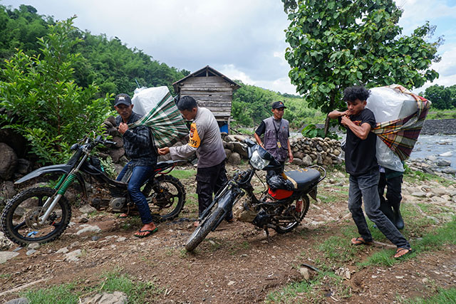 Personel kepolisian bersama petugas Bawaslu mendistribusikan logistik Pilkada 2024 ke Dusun Makmur, Desa Bonto Manurung, Kecamatan Tompobulu, Kabupaten Maros.