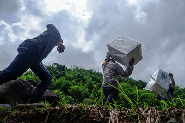 Personel kepolisian bersama petugas Bawaslu mendistribusikan logistik Pilkada 2024 ke Dusun Makmur, Desa Bonto Manurung, Kecamatan Tompobulu, Kabupaten Maros.