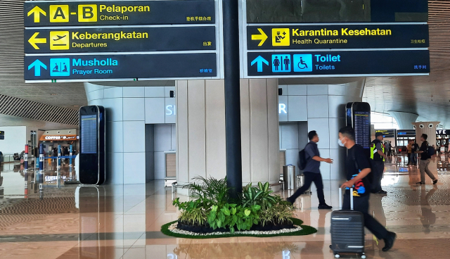 Calon penumpang berjalan di selasar Terminal Bandara Sultan Hasanuddin, Makassar.
