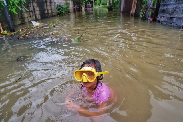 Anak-Anak Manfaatkan Banjir untuk Bermain