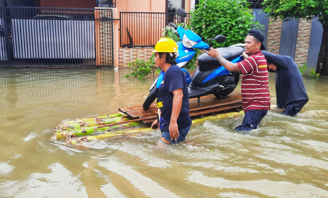 Warga mengevakuasi kendaraan  menggunakan rakit di Blok 10 Perumnas Antang, Makassar.