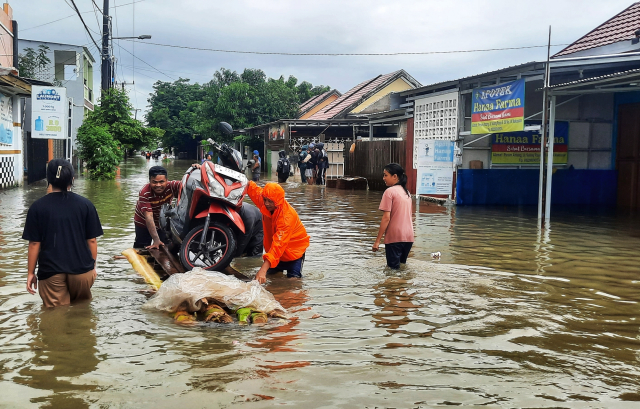 Warga mengevakuasi kendaraan  menggunakan rakit di Blok 10 Perumnas Antang, Makassar.