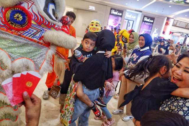 Tarian barongsai dengan diiringi dentuman tabuhan genderang dan simbal yang memeriahkan suasana.