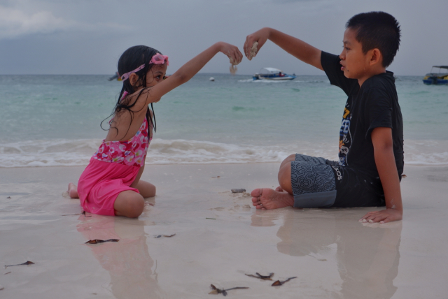 Mereka menikmati keindahan pantai yang terkenal dengan pasir putihnya yang lembut, air laut biru jernih, serta suasana alami yang tenang.