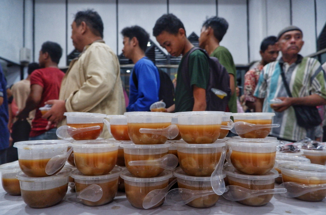 Umat Muslim terlihat mengantre dengan tertib untuk mendapatkan makanan buka puasa gratis di Masjid Al Markaz Al Islami, Makassar.