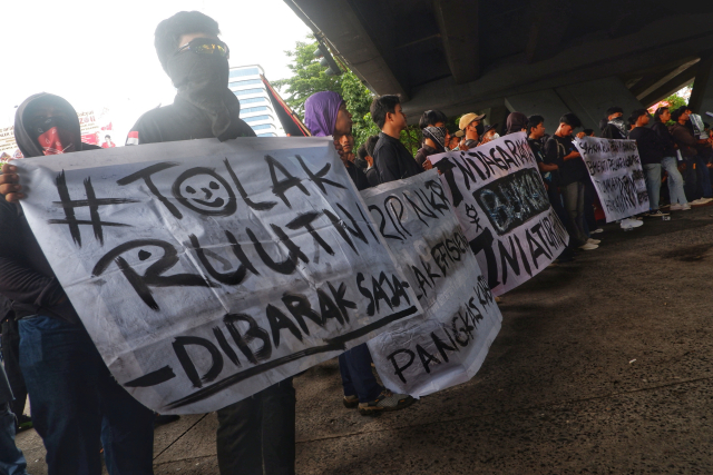 Mereka juga membawa poster bertulisan 'Tolak RUU TNI Kembalikan Militer ke Barak'.