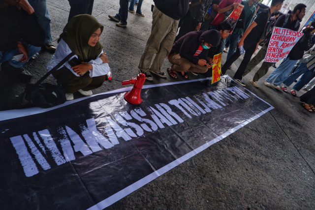 Mereka juga membawa poster bertulisan 'Tolak RUU TNI Kembalikan Militer ke Barak'.