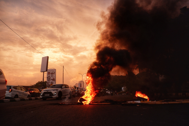 Aksi blokade jalan dengan membakar ban bekas sehingga menyebabkan kemacetan lalu lintas di Jalan Urip Sumoharjo, Makassar.