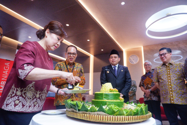 Presiden Direktur CIMB Niaga Lani Darmawan (kiri) melakukan pemotongan tumpeng saat meresmikan Digital Branch Makassar–Ahmad Yani di Makassar, Jumat (2/5/2025).
