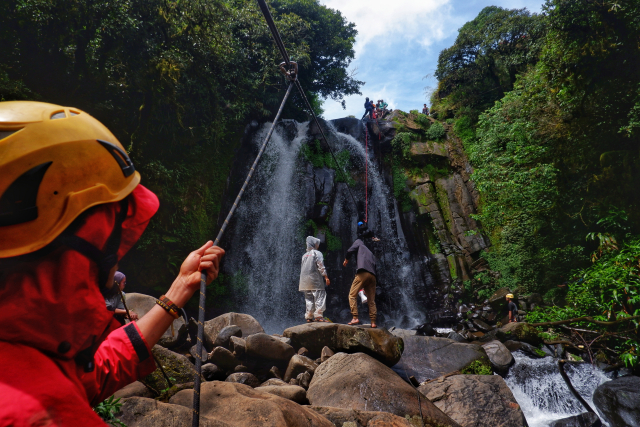 Didampingi oleh tim pemandu berpengalaman, mereka menelusuri medan curam dan menjajal atraksi ekstrem dengan menggunakan tali untuk meluncur dari atas air terjun.