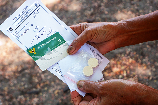Warga membawa obat yang diberikan usai melakukan pemeriksaan kesehatan secara gratis.