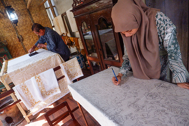 Seorang pembatik tradisional tampak tekun membatik kain dengan teknik cap di Batik Gunasti, Kampung Batik Kauman.