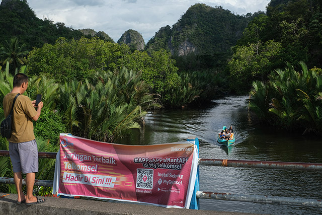 Pengunjung menikmati akses internet di kawasan wisata alam Karst Rammang-Rammang, Maros.