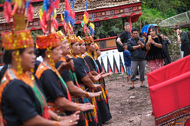 Kerabat keluarga menggunakan smartphone untuk merekam dan membagikan momen prosesi adat Rambu Solo di Toraja.