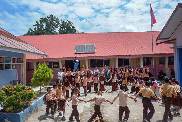 Petugas PLN memeriksa jaringan listrik dari unit mikro Pembangkit Listrik Tenaga Surya (PLTS) yang terpasang di atap sekolah dasar di Pulau Laiya, Kabupaten Pangkajene dan Kepulauan (Pangkep), Sulawesi Selatan. Sementara itu, para siswa tampak antusias mengikuti kegiatan bersama di halaman sekolah.