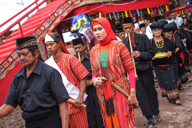 Warga berpakaian adat menyambut tamu dalam prosesi penerimaan di upacara Rambu Solo yang berlangsung di kompleks Tongkonan Layuk, Kabupaten Tana Toraja, Sulawesi Selatan.