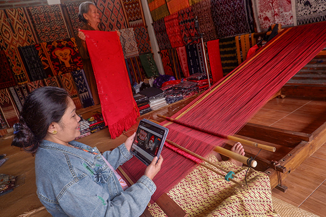 Penenun tradisional mengakses informasi layanan tabungan digital CIMB Niaga melalui perangkat tablet di Desa Sa'dan To'barana, Kecamatan Sa'dan, Toraja Utara.