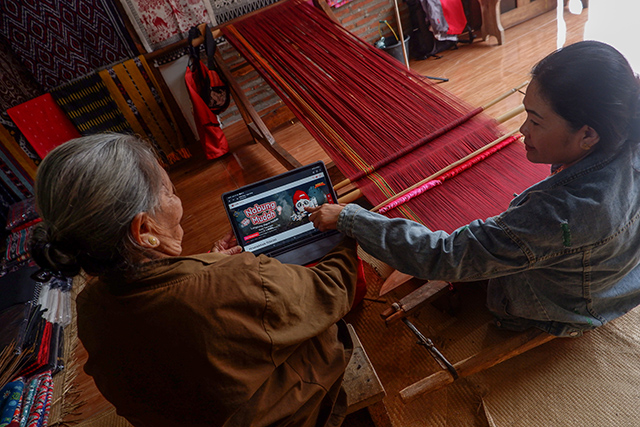 Penenun tradisional mengakses informasi layanan tabungan digital CIMB Niaga melalui perangkat tablet di Desa Sadan Tobarana, Kecamatan Sadan, Toraja Utara.