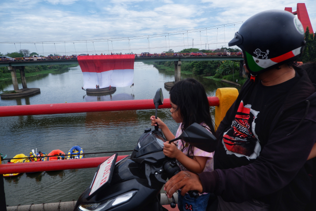 Warga menyaksikan pembentangan bendera berukuran 20 meter kali 15 meter yang digelar oleh Komunitas Pemerhati Aliran Sungai Celebes bersama Indonesia Off-Road Federation (IOF) Pengcab Gowa.