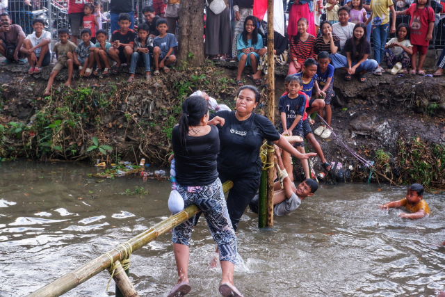 Peserta tampak antusias saling memukul  saat mengikuti lomba pukul bantal di atas kanal Tello.