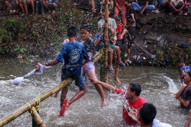 Peserta tampak antusias saling memukul  saat mengikuti lomba pukul bantal di atas kanal Tello.