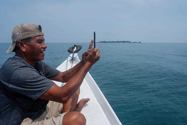 Seorang warga menggunakan smartphone di atas kapal penumpang tradisional di Pulau Sabutung, Pangkep, Sulawesi Selatan.