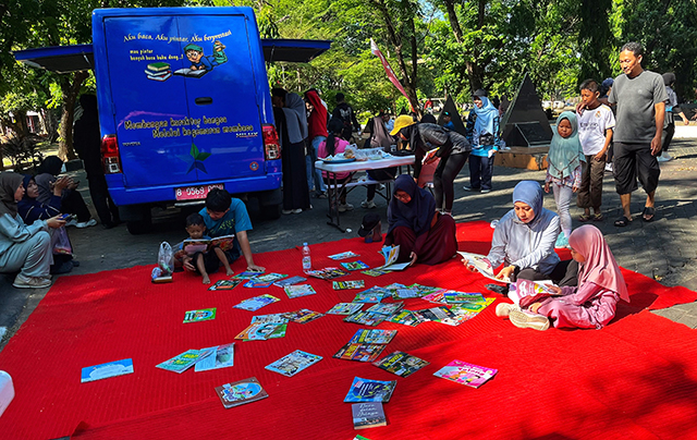 Pengunjung, termasuk anak-anak dan orang tua, tampak antusias membaca berbagai koleksi bacaan yang disediakan perpustakaan keliling Unhas saat kegiatan car free day di kampus Universitas Hasanuddin.