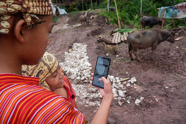 Dua anak di Tana Toraja mencoba mengakses aplikasi OCTO Mobile CIMB Niaga melalui ponsel pintar mereka.