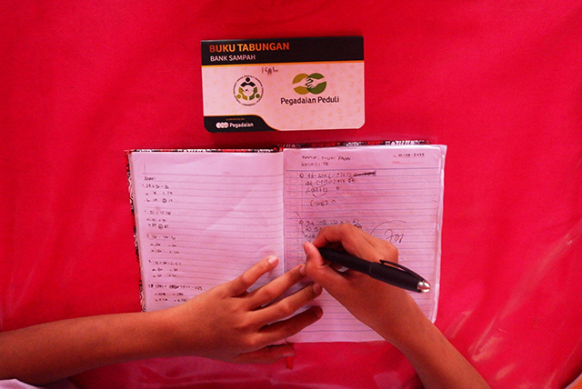 Muh Fadel, siswa SMP Negeri 27 Makassar, saat belajar di kelas. Di atas mejanya terlihat buku tabungan Bank Sampah hasil kerja sama sekolah dengan PT Pegadaian.