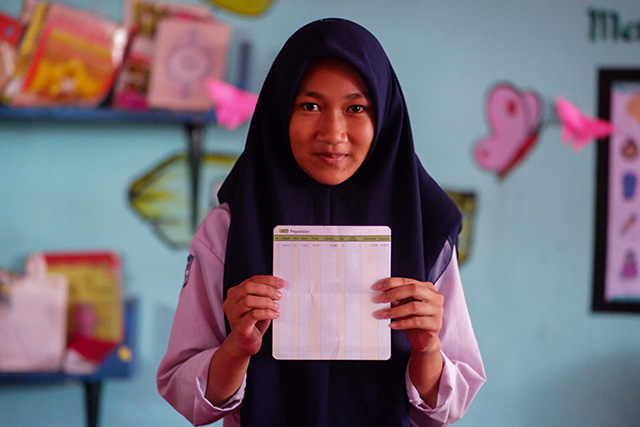 Meylisa Auliah, siswa SMP Negeri 27 Makassar, memperlihatkan buku tabungan emas hasil dari kegiatan Bank Sampah “Singara’na 27” yang bekerja sama dengan PT Pegadaian.