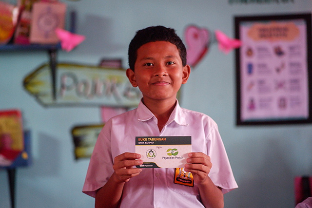 Muh Fadel, siswa SMP Negeri 27 Makassar, memperlihatkan buku tabungan emas hasil dari kegiatan Bank Sampah “Singara’na 27” yang bekerja sama dengan PT Pegadaian.