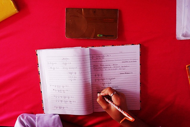 Novita Putri Iskandar, siswa SMP Negeri 27 Makassar, saat belajar di kelas. Di atas mejanya terlihat buku tabungan Bank Sampah hasil kerja sama sekolah dengan PT Pegadaian.