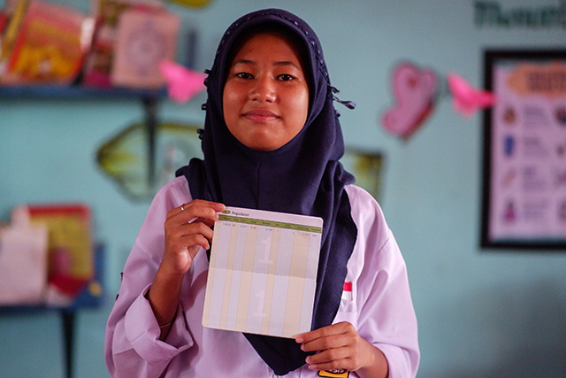 Novita Putri Iskandar, siswa SMP Negeri 27 Makassar, memperlihatkan buku tabungan emas hasil dari kegiatan Bank Sampah “Singara’na 27” yang bekerja sama dengan PT Pegadaian.