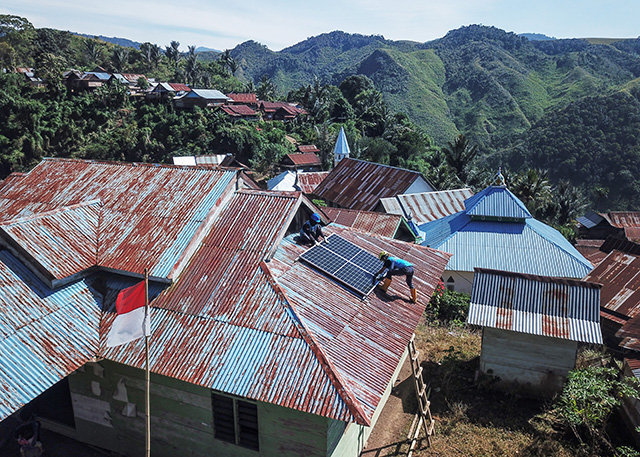 teknisi memasang panel surya SuperSUN di atap kantor desa  Dusun Amballong, Kecamatan Seko, Luwu Utara.