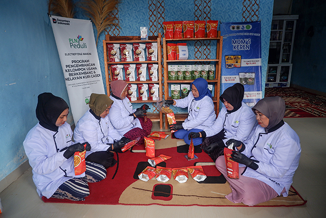 Para anggota kelompok UMKM Moms Keren menyiapkan kemasan produk keripik kepiting rajungan di rumah produksi mereka di Dusun Kuri Caddi, Desa Nisombalia, Kecamatan Marusu, Kabupaten Maros, Sulawesi Selatan, Sabtu (18/10/2025).