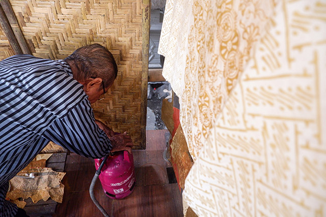 Sukadi memasang tabung Bright Gas Pertamina yang digunakan untuk memanaskan lilin batik.