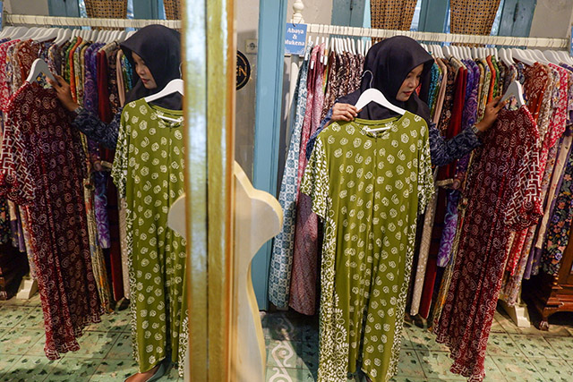Seorang pengunjung memilih busana batik modern di galeri Batik Gunasti, Kampung Batik Kauman, Solo. Inovasi desain dan ragam warna menjadikan batik tradisional semakin diminati generasi muda tanpa meninggalkan nilai budaya yang diwariskan turun-temurun.