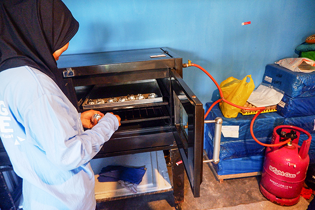 Seorang peserta pelatihan memasukkan telur bebek ke dalam oven saat proses pembuatan telur asin oven di Desa Baji Mangngai, Kecamatan Mandai, Kabupaten Maros, Sulawesi Selatan, Selasa (02/09/2025). Kegiatan ini merupakan bagian dari program CSR Pertamina Patra Niaga Aviation Fuel Terminal Hasanuddin untuk mendukung peningkatan keterampilan dan kemandirian ekonomi masyarakat.