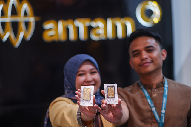 Dua karyawan memperlihatkan sampel emas batangan yang ditawarkan kepada pelanggan di Butik Emas Logam Mulia (LM) ANTAM, Makassar, Selasa (07/11/2025).
