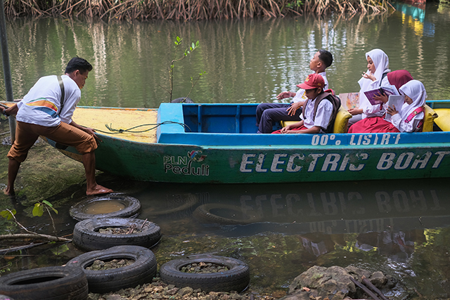 Sunardi bersiap mengantar anak-anak sekolah melintasi sungai di Desa Berua, Rammang-Rammang. Transportasi ramah lingkungan ini kini menjadi tumpuan mobilitas harian warga.