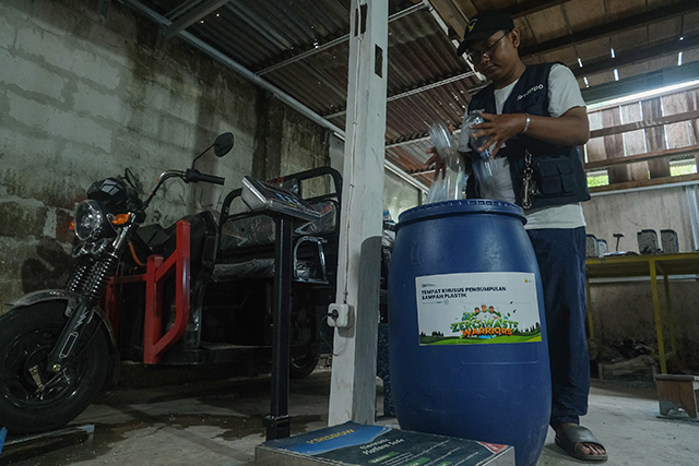 Wanda pekerja Rappo Indonesia memasukkan botol plastik ke wadah pengumpulan sampah di rumah produksi Untia, Makassar, sebagai bagian dari program TJSL PLN untuk mengolah sampah menjadi produk bernilai ekonomi.