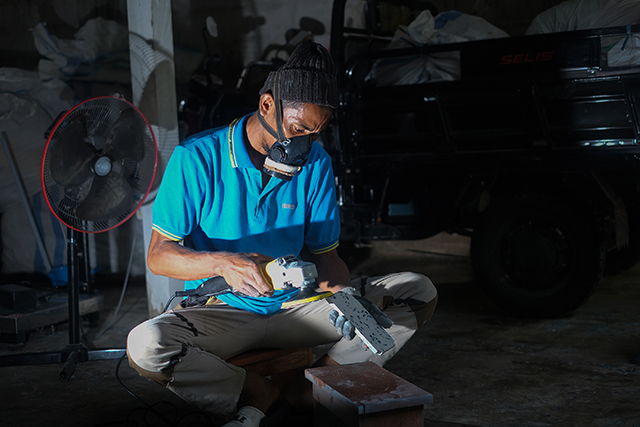 Rosandi merapikan material plastik daur ulang di rumah produksi Rappo Indonesia, bagian dari program TJSL PLN yang mendorong ekonomi hijau di pesisir.