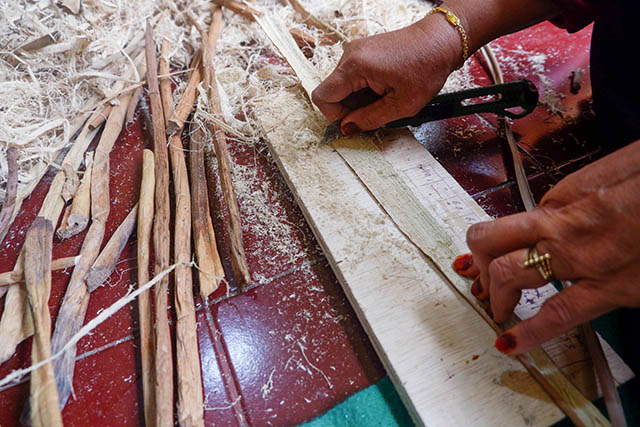 Seorang perajin Komunitas Kasih Bunda menghaluskan batang eceng gondok sebelum dianyam menjadi berbagai produk kerajinan.