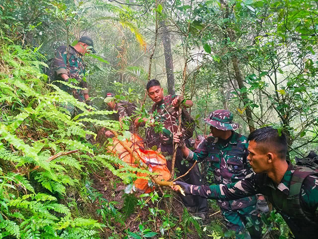 Prajurit TNI mengevakuasi korban kecelakaan pesawat ATR 42-500 dari kawasan hutan lebat di lereng Gunung Bulusaraung. (Dok.Tim SAR)