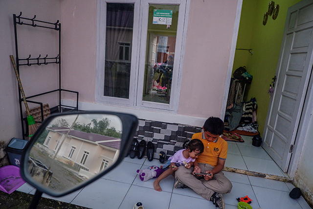 Dua anak bermain di halaman teras perumahan subsidi di Kecamatan Tanralili, Kabupaten Maros, menampilkan suasana hunian yang nyaman dan ramah keluarga.