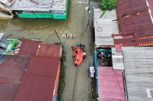 Sejumlah warga mengungsi ke tempat aman saat terjadi banjir di Blok 10 Perumnas Antang, Makassar.