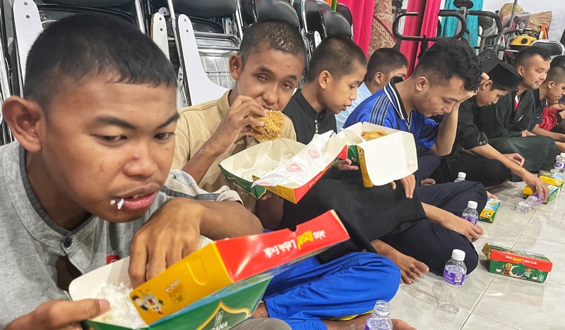 Para siswa menyantap hidangan buka puasa bersama yang telah disiapkan.